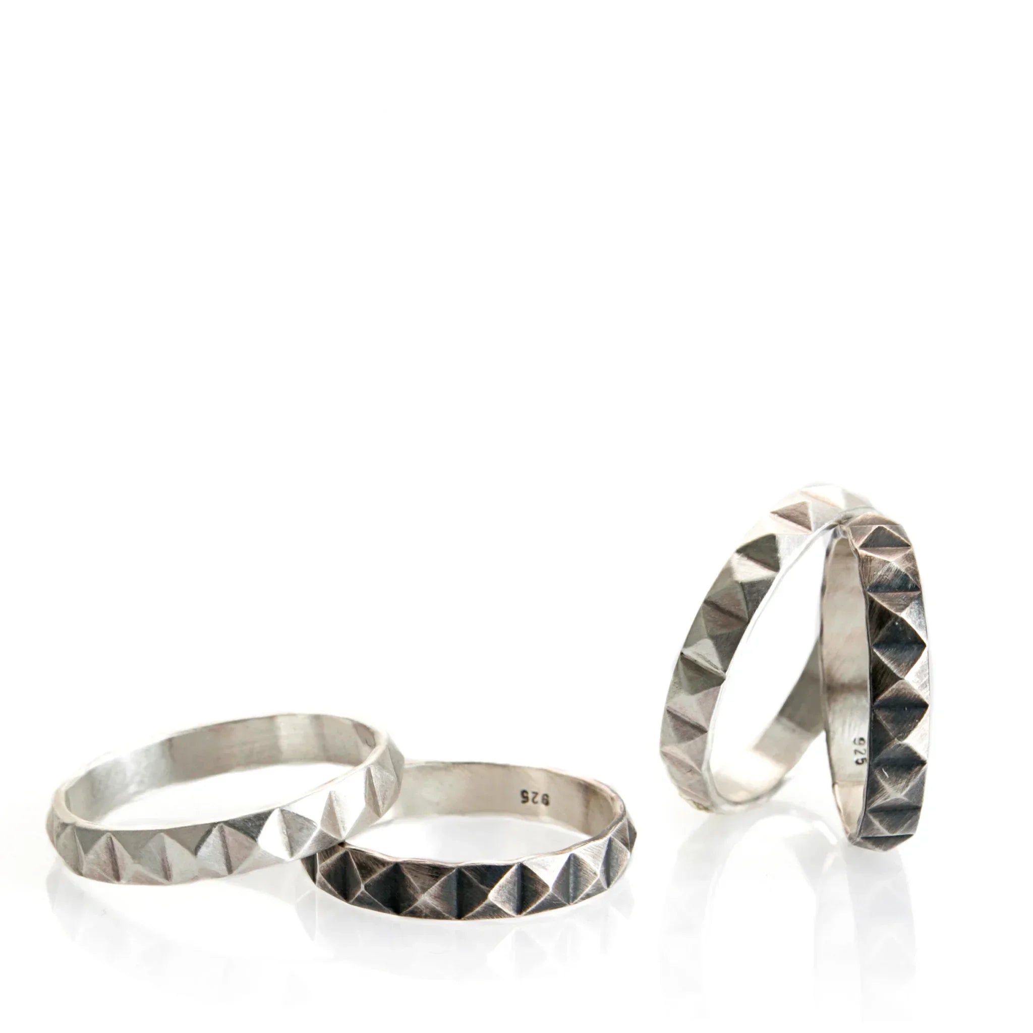 Silver studded geometric rings with pyramid pattern on white background