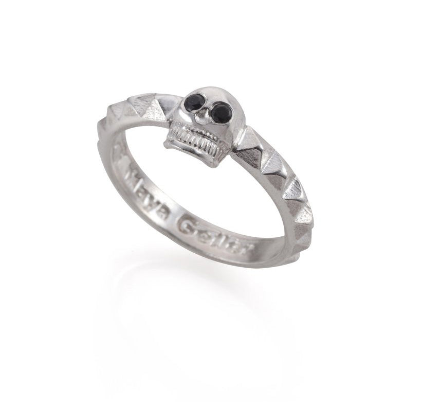 A silver ring with a skull design and studs on the band.